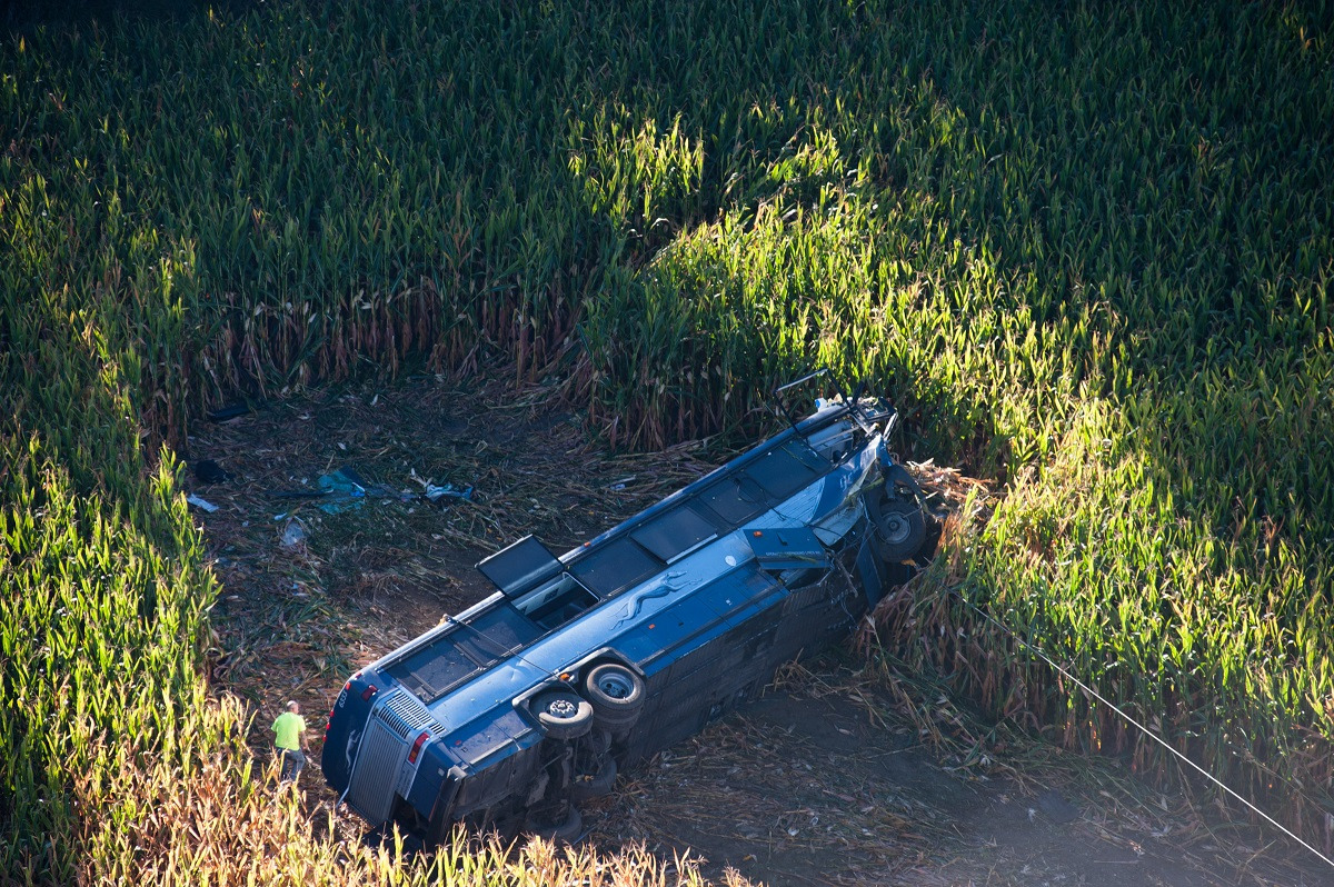 A greyhound bus overturned in a field after an accident.