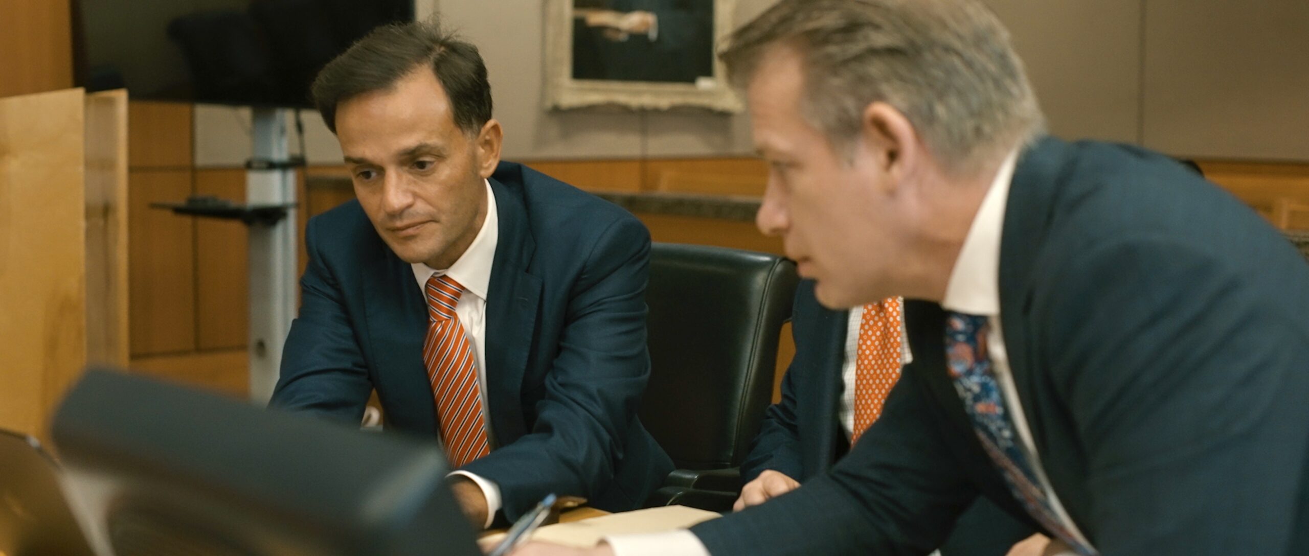 Two Zehl & Associates trial attorneys in suits, seated in the courtroom.